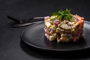 Delicious fresh Olivier salad with sausage, egg, cucumber, green peas, carrots and mayonnaise photo