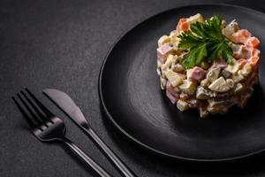 Delicious fresh Olivier salad with sausage, egg, cucumber, green peas, carrots and mayonnaise photo