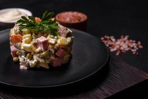 Delicious fresh Olivier salad with sausage, egg, cucumber, green peas, carrots and mayonnaise photo