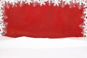 White snowflakes on red shiny background with snow. Frame for  announcement. Christmas, New Year. Copy space photo