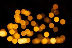 Yellow defocused lights, bokeh on black background, overlay. Design element. Christmas, New Year photo