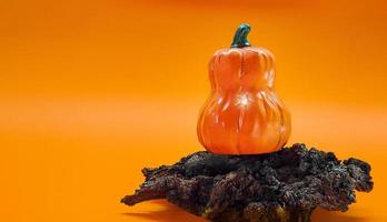 calabaza de halloween con brillo en un espeluznante enganche sobre fondo naranja. espacio de copia foto