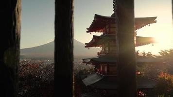 Video 4k uhd de la pagoda chureito, japón al atardecer con el monte fuji al fondo.