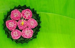krathong de hoja de plátano con 3 varitas de incienso y velas decoradas con flor de loto rosa para la luna llena de tailandia o el festival loy krathong. foto