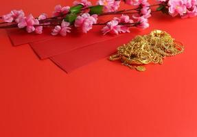 fondo de año nuevo chino - sobre rojo, flor de ciruela y adorno de oro foto