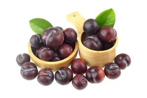 Wooden bowl with fresh plum and lums around the bowls photo