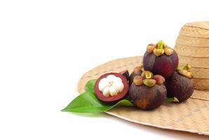 Group of mangosteens with it leaves on weaven hat photo