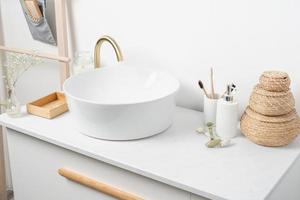 Bathroom marble counter with sink, candles and toothbrushes near white wall, copy space photo