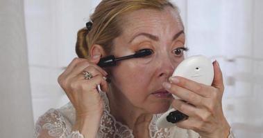 una chica hermosa aplica maquillaje relacionado con la edad en su rostro video
