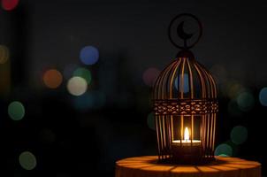 Beautiful Lantern that have moon symbol on top with city bokeh light on dark background. photo