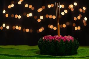 krathong de hoja de plátano con 3 varitas de incienso y velas decoradas con flor de loto rosa para la luna llena de tailandia o el festival loy krathong. foto