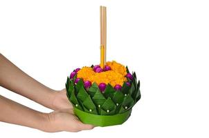 mano sosteniendo krathong de hoja de plátano para tailandia luna llena o festival loy krathong aislado sobre fondo blanco. foto