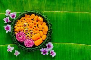 postres de boda tailandeses en plato de hojas de plátano o krathong decorados con flor de loto para la ceremonia tradicional tailandesa sobre fondo de hoja de plátano. foto