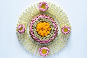Thai wedding desserts on plate or krathong made from pink lotus petal and crown flower for thai traditional ceremony on white background. photo