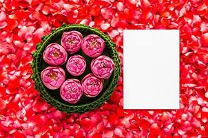 Banana leaf Krathong with lotus flowers for Thailand Full moon or Loy Krathong festival with space for text on red rose petals background.