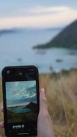 tomando fotos de la costa en el este de indonesia usando un teléfono inteligente