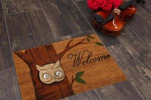 New Delhi, Delhi, IN, 2022 - Beautiful Colorful Welcome zute doormat with Tree and Night Owl placed on brown floor with Guitar photo