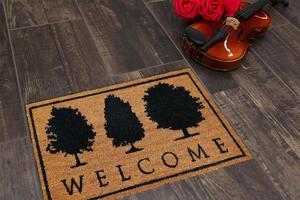 New Delhi, Delhi, IN, 2022 - Beautiful welcome doormat peach color with black tree placed with Guitar and Red Roses photo