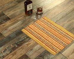 New Delhi, Delhi, IN, 2022 - Beautiful Beige color Ruff Welcome zute doormat with Striped placed with Whiskey and Glass photo