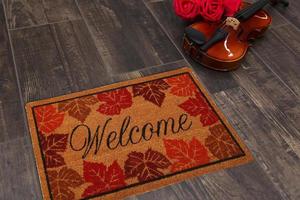 New Delhi, Delhi, IN, 2022 - Beautiful Colorful Leaf Printed Welcome zute doormat placed on brown floor with Guitar photo