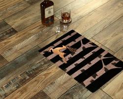 New Delhi, Delhi, IN, 2022 - Beautiful Black Gold Welcome zute doormat with trees and deer placed with Whiskey and Glass photo