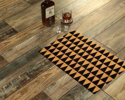 New Delhi, Delhi, IN, 2022 - Modern zig-zag patterned yellow black welcome zute doormat placed with Whiskey and Glass photo