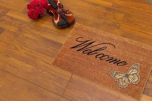 New Delhi, Delhi, IN, 2022 - Beautiful welcome peach color coir doormat with Butterfly placed with Guitar and Red Roses photo