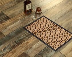 New Delhi, Delhi, IN, 2022 - Modern Honeycomb design peach color doormat with black border placed with Whiskey and Glass photo