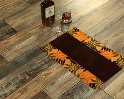 New Delhi, Delhi, IN, 2022 - Beautiful Colorful Leaf Printed Welcome zute doormat placed with Whiskey and Glass photo