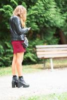 Young woman stops to look at the smartphone photo