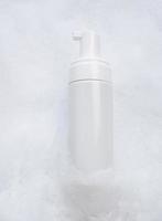 White plastic tube mockup with moisturizer cream, shampoo or facial cleanser and gentle soap foam with bubbles on marble background, top view. Treatment spa beauty skincare cosmetic product photo