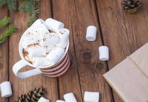 chocolate caliente dulce con malvaviscos, bebida navideña de invierno sobre fondo de madera. foto