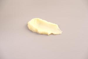 Cosmetic products creamy yellow texture stain nude beige background. The texture of natural cosmetics hair mask, cream, scrub. photo