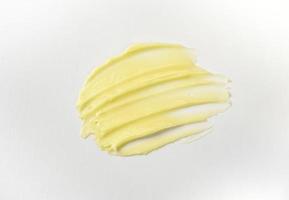 Cosmetic products creamy yellow stain texture on a white background. The texture of natural cosmetics hair mask, cream, scrub. photo