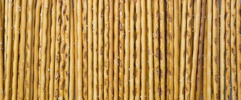 Background from sticks of crackers with salt. Food concept. Edible snacks dry sticks with salt. Texture from straws, crackers sticks. photo