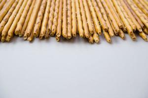 Background from sticks of crackers with salt on a gray background. Food concept. Edible snacks dry sticks with salt. Texture from straws, crackers sticks. photo