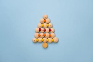 Christmas tree made of cookies and sweets on a blue background with space for text. Christmas baking concept. photo