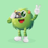 Cute green monster taking photo with camera vector