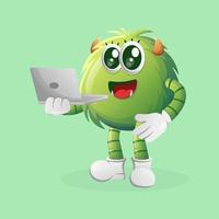 Cute green monster working using a laptop vector