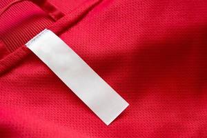 White blank clothes label on red jersey texture background photo