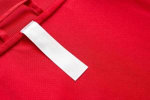 White blank clothes label on red jersey texture background photo