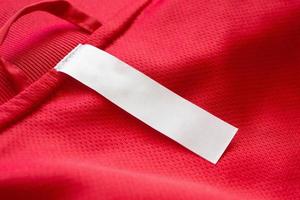 White blank clothes label on red jersey texture background photo