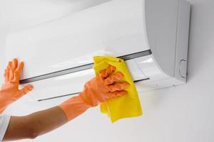 Asian man cleaning air conditioner with microfiber cloth photo