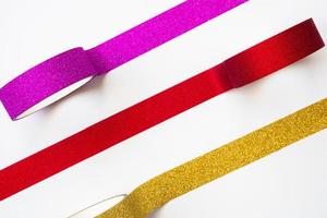 colorful glitter tape rolls strips on white background photo