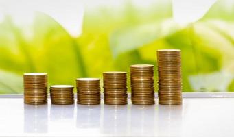 finanzas empresariales y concepto de dinero, gráfico de crecimiento de la pila de monedas de dinero con fondo de bokeh de árbol verde, concepto de inversión foto