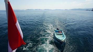 Boat tagged behind sail boat photo