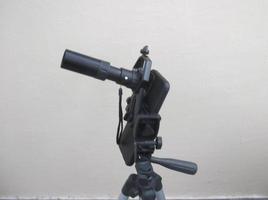 Attachment between monocular telescope and smartphone on a tripod photo