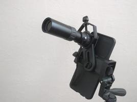 Attachment between monocular telescope and smartphone on a tripod photo