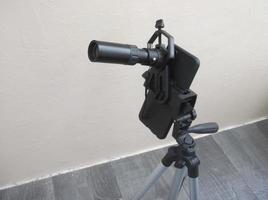 Attachment between monocular telescope and smartphone on a tripod photo