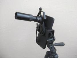 Attachment between monocular telescope and smartphone on a tripod photo